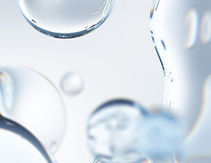Close-up of transparent water droplets on a light background, creating a soft, abstract effect.