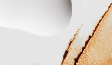 Abstract close-up of a textured surface featuring a smooth white background with a streak of brownish-orange paint or material on the right side.