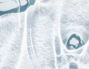Abstract close-up of translucent ice, showcasing intricate textures and patterns with a cool blue tint.