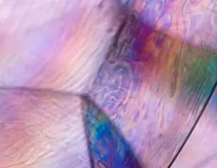 Abstracte close-up van kleurrijke, iriserende patronen die lijken op licht dat door een zeepbel wordt gebroken.