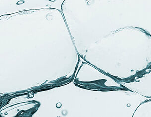 Doorzichtig water met luchtbellen en ijsblokjes die samenkomen en een dynamische tekstuur creeren.