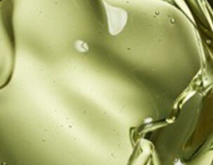 Close-up van een groene vloeistof met een glanzende textuur en luchtbelletjes.