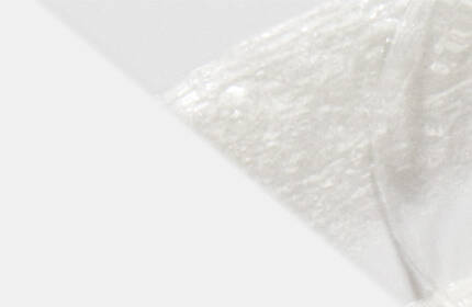 Close-up of a smooth, white substance with a soft, textured appearance, set against a light background.