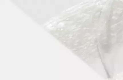 Close-up of a smooth, white substance with a soft, textured appearance, set against a light background.