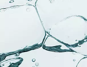 Close-up of ice cubes submerged in clear water, with bubbles rising and creating a refreshing, cool atmosphere.