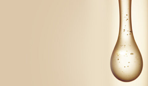 Abstract image featuring a smooth, elongated droplet shape with bubbles, set against a soft, warm background.