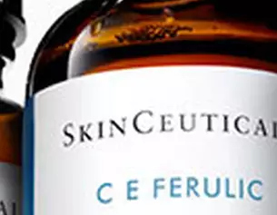Drie glazen flessen SkinCeuticals C E Ferulic serum met een klein glasnetje ernaast.