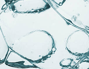 Close-up van helder water met luchtbellen en druppels die samen een abstracte, verfrissende uitstraling creeren.