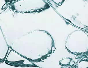 Close-up van helder water met luchtbellen en druppels die samen een abstracte, verfrissende uitstraling creeren.