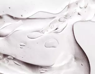Abstracte close-up van transparante vloeistof met druppels op een glanzend oppervlak.