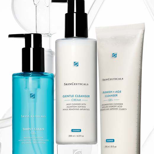 Drie flessen huidverzorgingsproducten van SkinCeuticals, waaronder een reiniger en een anti-aging cleanser, op een lichte achtergrond.