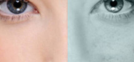 A close-up split image of an eye with one side showing a natural skin tone and the other in grayscale, highlighting contrasting textures and colors.