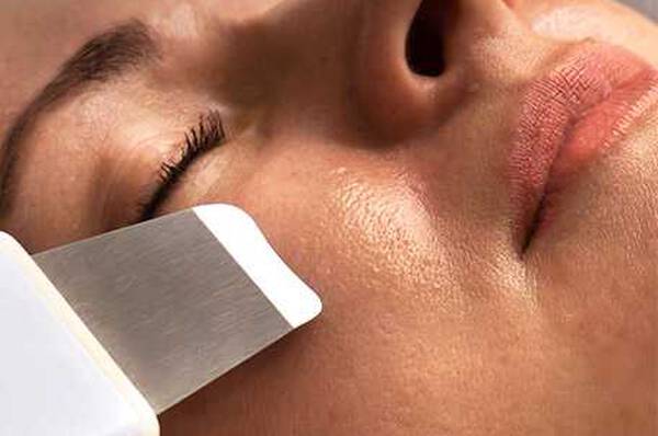 Een close-up van een gezicht waarop een huidverzorgingsapparaat wordt gebruikt. De huid ziet er glad en glanzend uit.