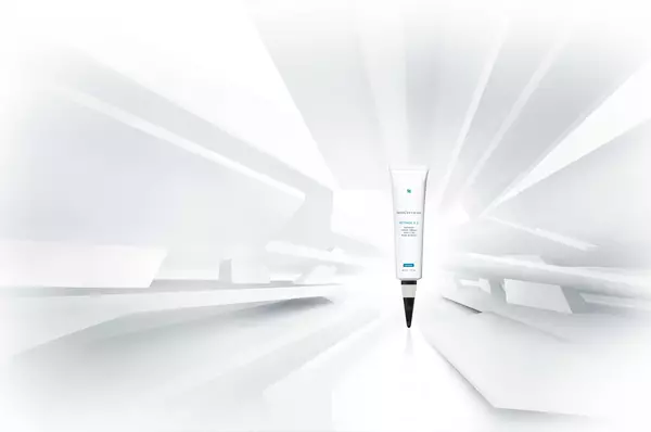 Een tube huidverzorgingsproduct staat centraal in een abstracte, witte omgeving met een futuristische uitstraling.