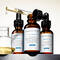 Drie flessen met huidverzorgingsserums van SkinCeuticals, waaronder C E Ferulic, Phloretin CF en Serum 10, staan op een schap met een pipet en een glazen houder.