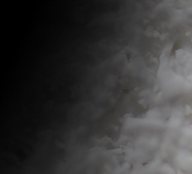 Abstracte afbeelding met donkere en lichte wolkenachtige structuren, die een mysterieuze sfeer oproept.